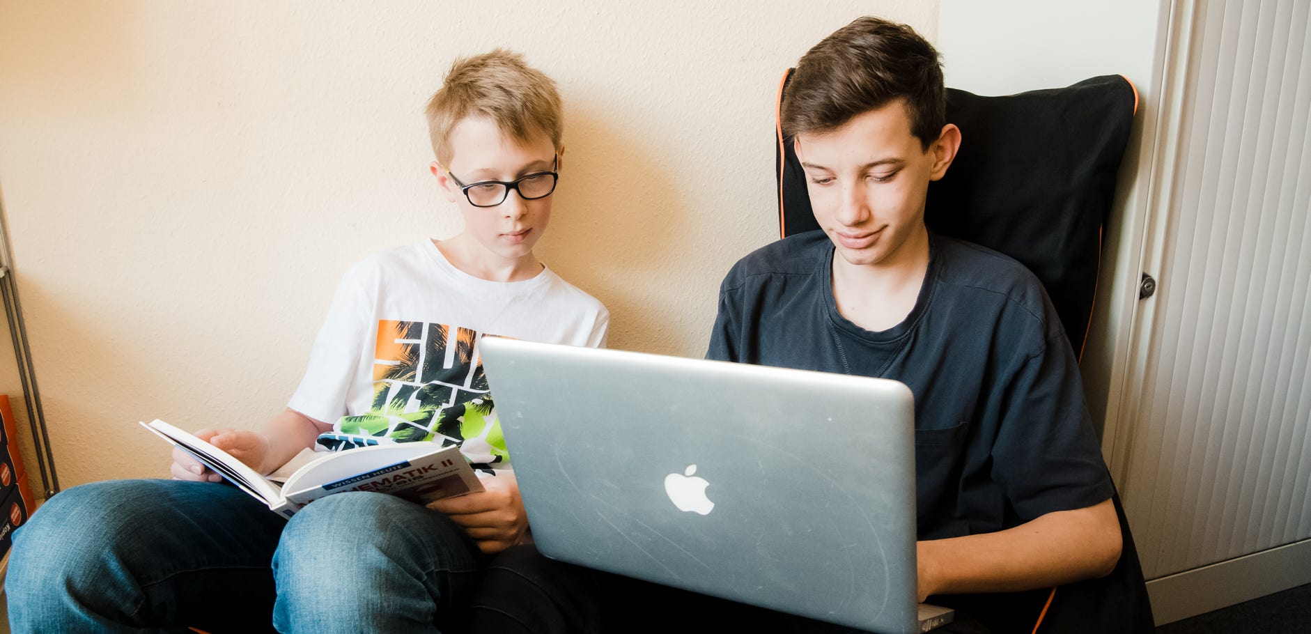 Junge mit Laptop beim Online lernen